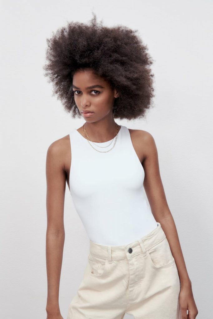 Halter neck bodysuit with snap-button fastening at the bottom.